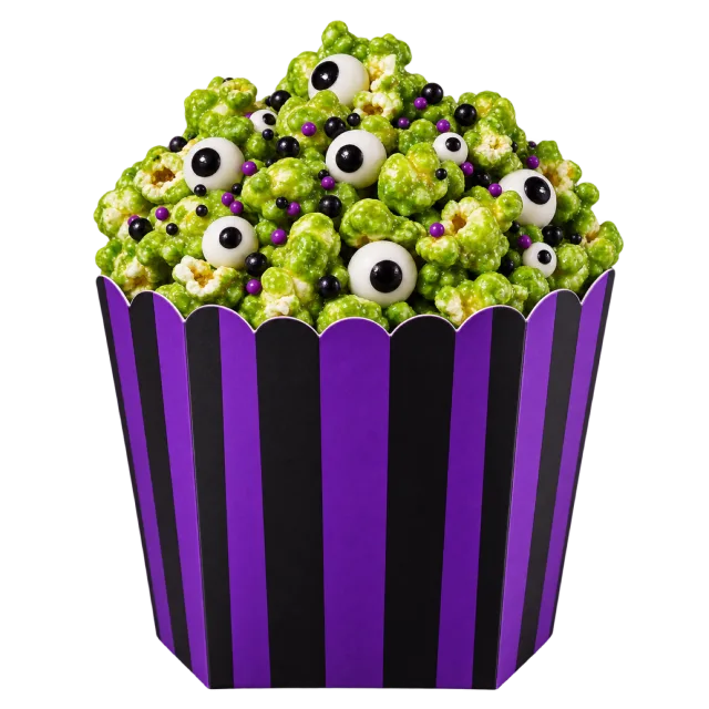 Green popcorn mixed with candy eyes in a purple and black striped carton