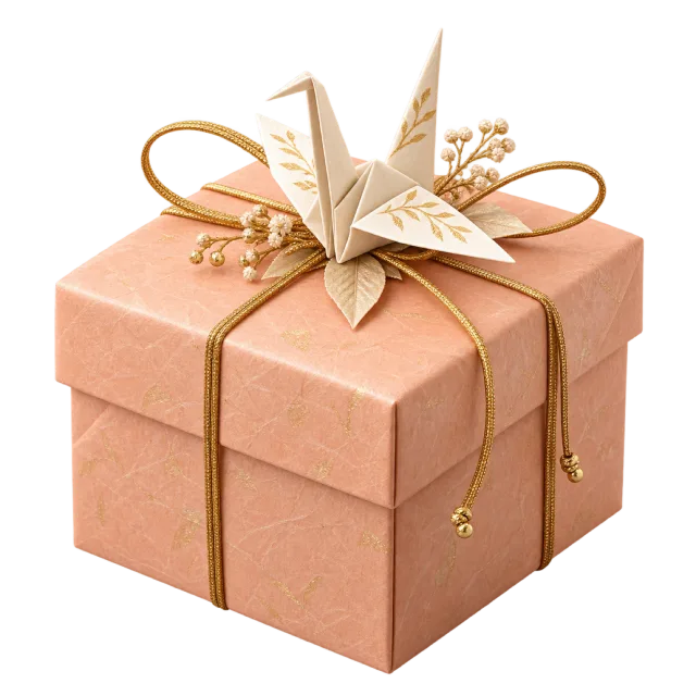 A peach-colored box topped with a folded paper crane, fine gold-colored cord and dried floral accents