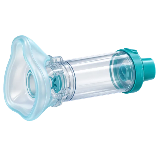 A clear inhaler spacer has a face mask and teal fittings