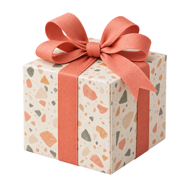 A cream cube present with multicolored terrazzo-style flecks and a coral ribbon bow
