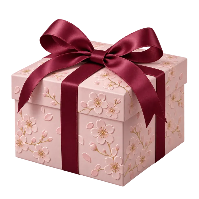 A pale pink box with blossom patterns and a deep red satin-style ribbon