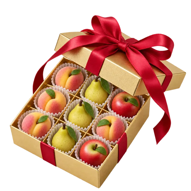 A gold gift box filled with miniature fruit-shaped sweets beneath a red ribbon bow