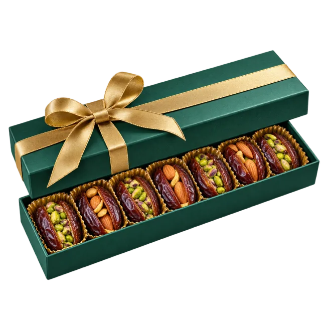 A long green gift box filled with split dates and colorful nut fillings, tied with a gold ribbon