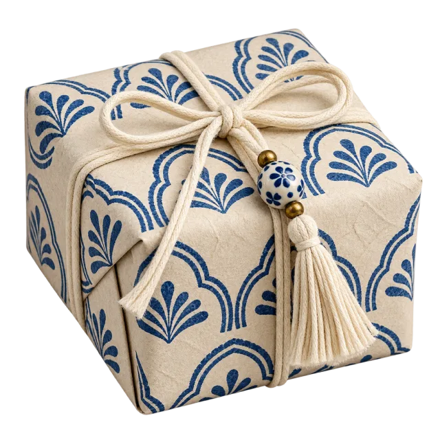 Cream parcel with blue block-print-style patterns, a cord bow and tassel