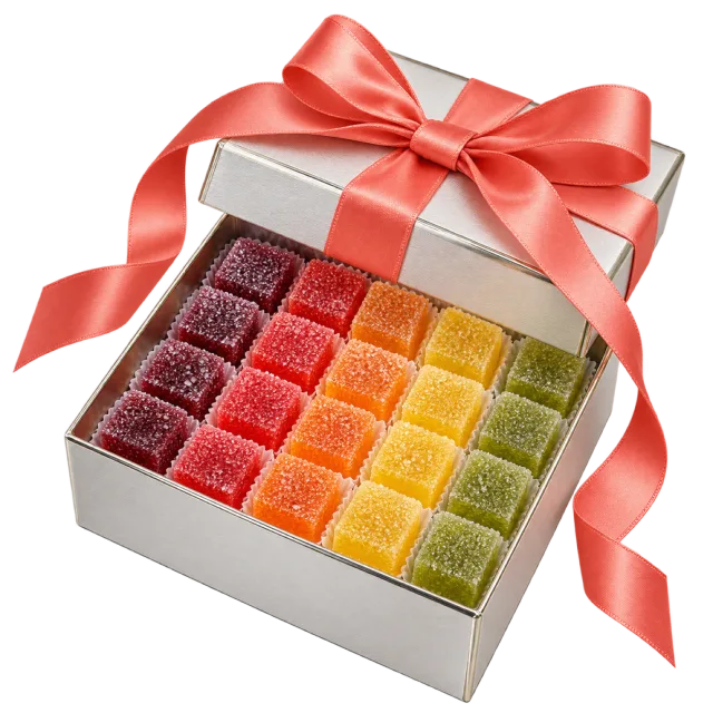 Open white box with rows of colorful square jelly sweets and a coral bow