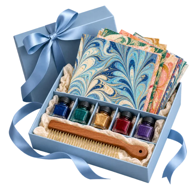 Pale blue craft box containing marbled papers, colored inks and a comb-like tool