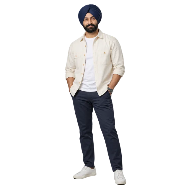 Man wearing a navy turban, cream overshirt, white T-shirt and dark trousers