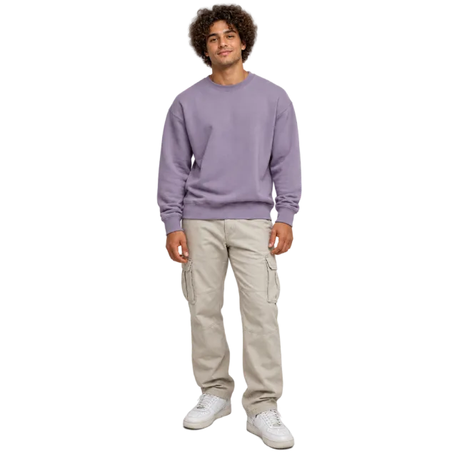 Man with curly hair wearing a lavender sweatshirt, beige trousers and white sneakers