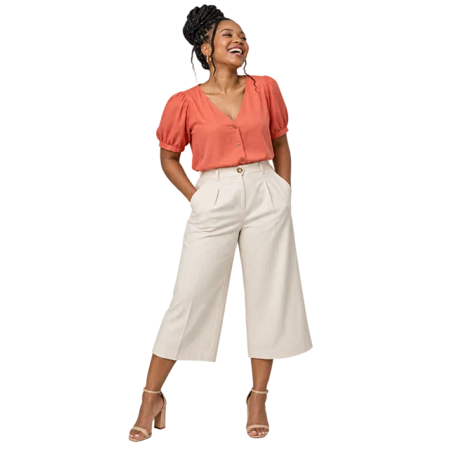 Woman laughing in a coral blouse and cream cropped wide-leg trousers