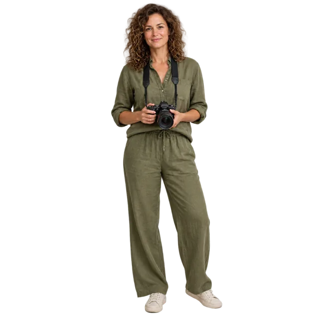 Woman in an olive outfit holding a black camera at waist level