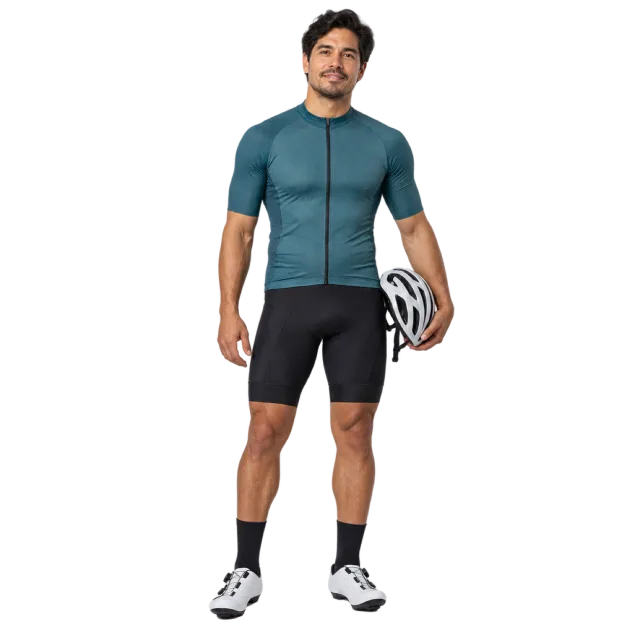 Man in a teal cycling jersey and black shorts holding a helmet