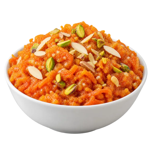 Orange gajar halwa in a white bowl topped with sliced nuts