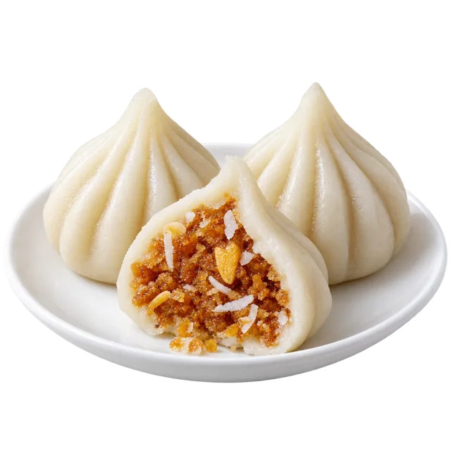 White pleated modak with one cut open to show a brown textured filling