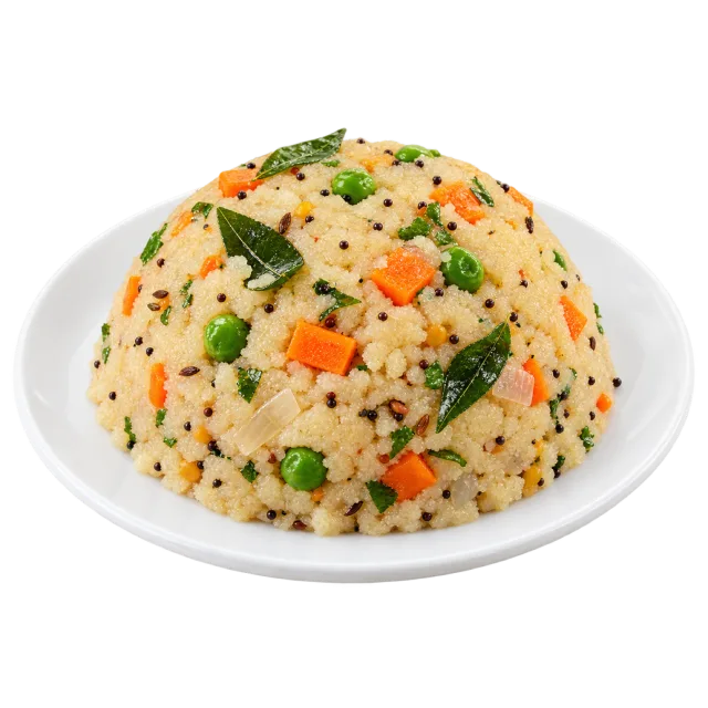 Domed vegetable upma with peas, carrot pieces and curry leaves on a plate