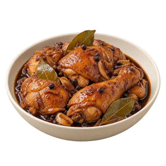 Chicken adobo with browned chicken pieces, bay leaves and dark sauce in a bowl