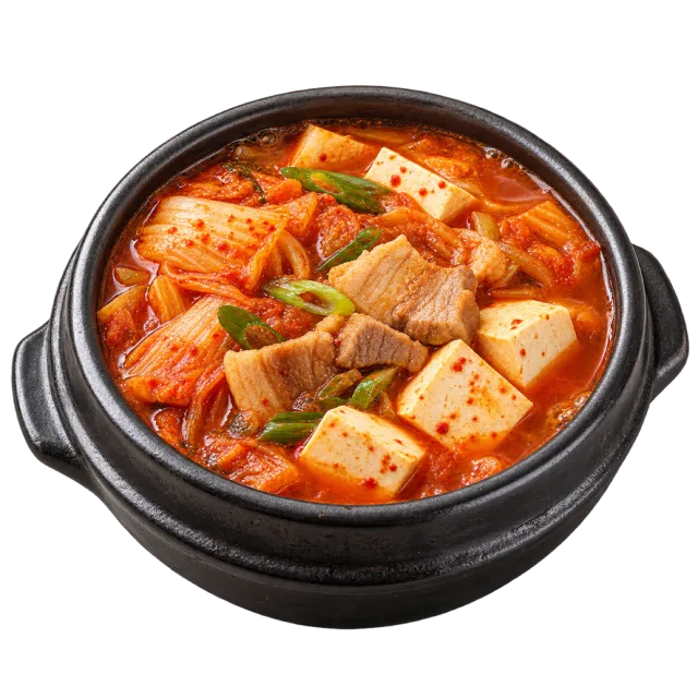 Kimchi jjigae in a black pot with red broth, tofu pieces and sliced green onion