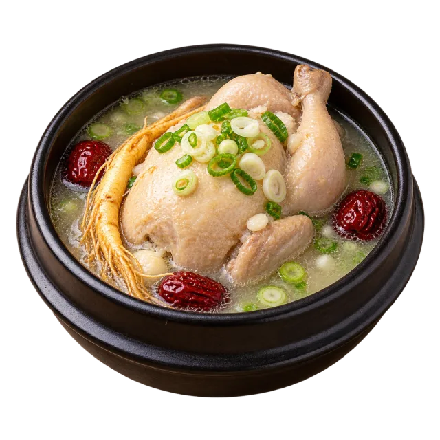 Samgyetang in a black bowl with a small whole chicken, pale broth and green onion