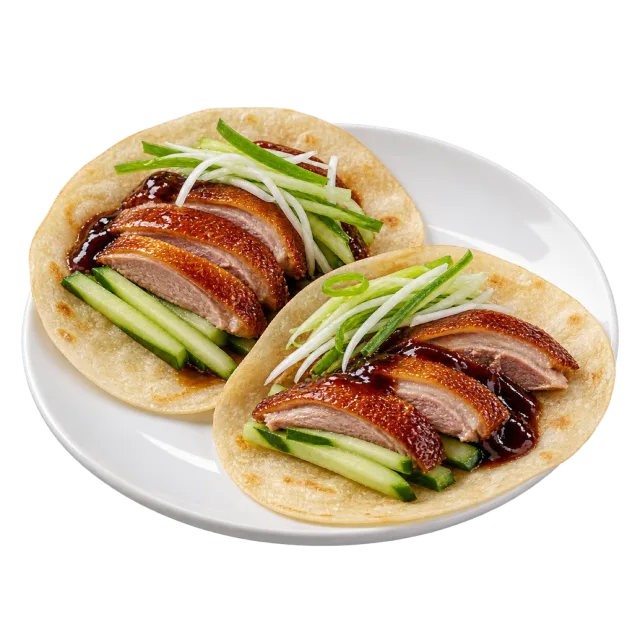 Two open pancakes holding duck slices, cucumber and thin green onion strips