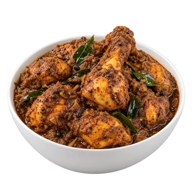 Chettinad chicken with browned chicken pieces, dark textured coating and green leaves