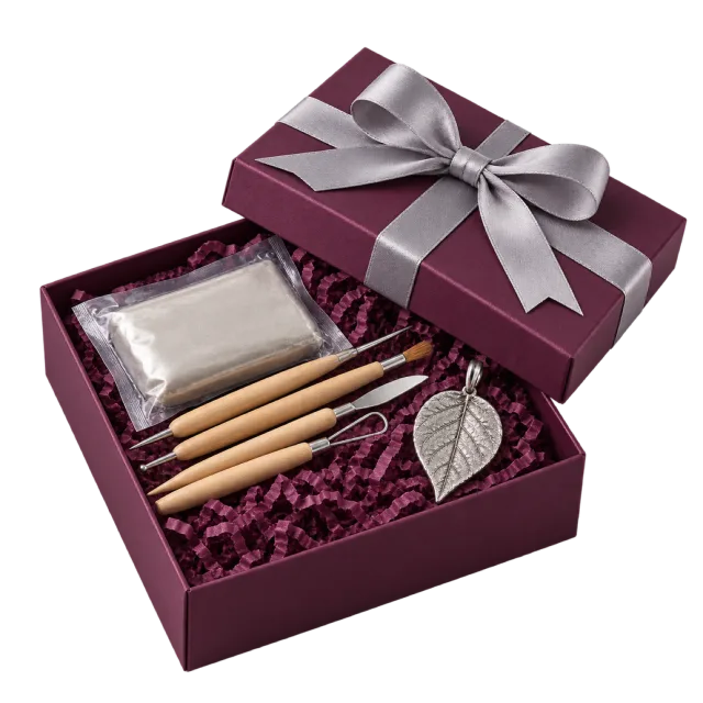 Burgundy jewelry craft gift box with sculpting tools and a leaf-shaped pendant