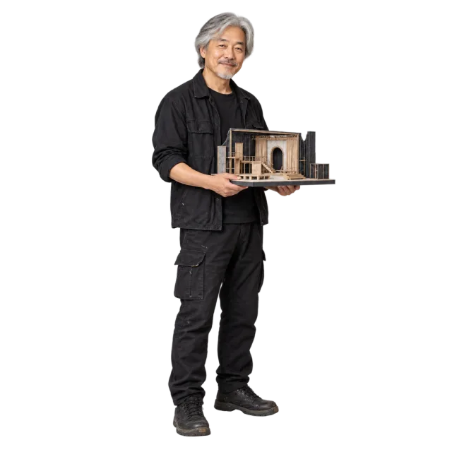 Gray-haired man in black clothing holding a miniature stage model