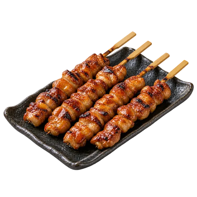 Glazed grilled chicken skewers arranged on a black rectangular plate
