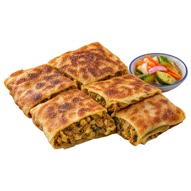 Browned stuffed flatbread cut into square portions beside pickled vegetables