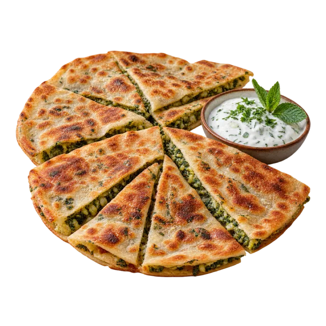 Wedges of browned stuffed flatbread with a green filling beside a creamy dip