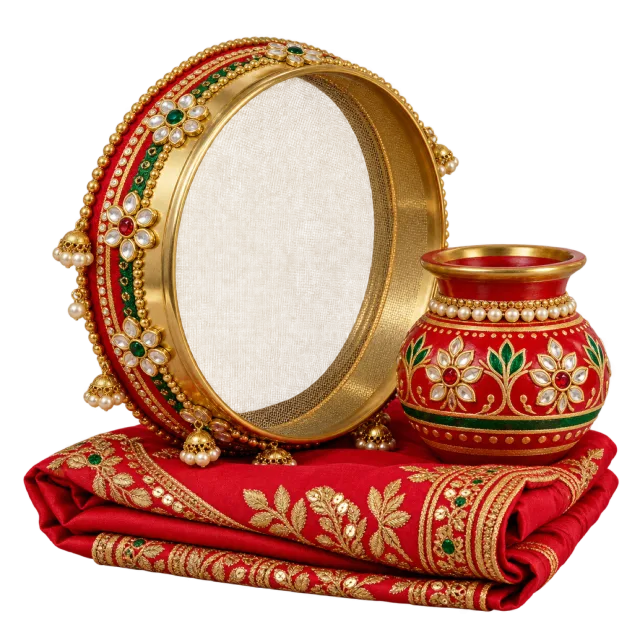 Decorated round sieve and red pot resting on folded red embroidered fabric