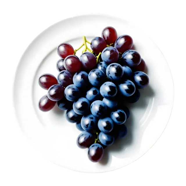 Dark blue and red grapes arranged on a plain oval white plate on a transparent background