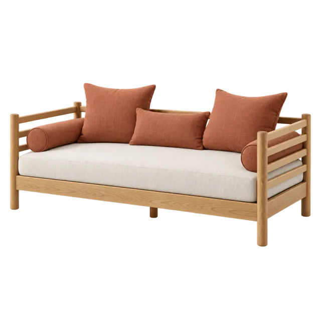 A wooden daybed with slatted arms, a cream seat and rust-colored pillows