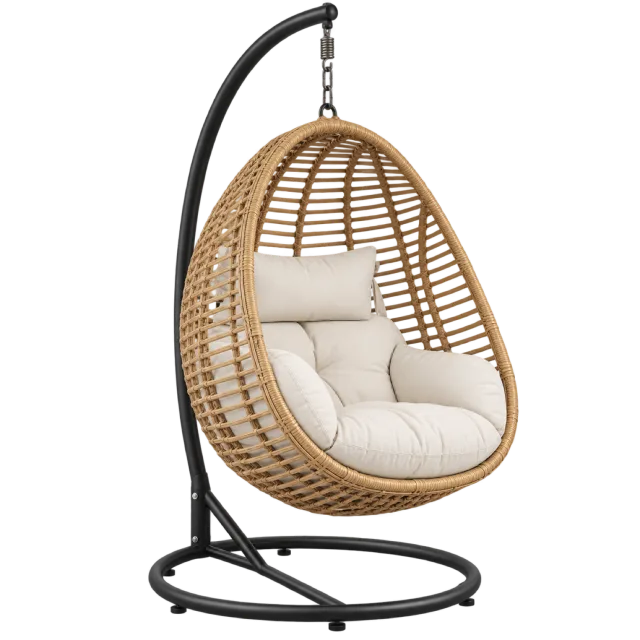 A woven egg-shaped chair with cream cushions suspended from a black metal stand