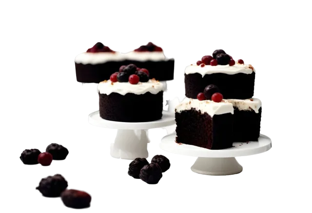 Chocolate and cream cake slices on white stands with scattered dark berries on a transparent background