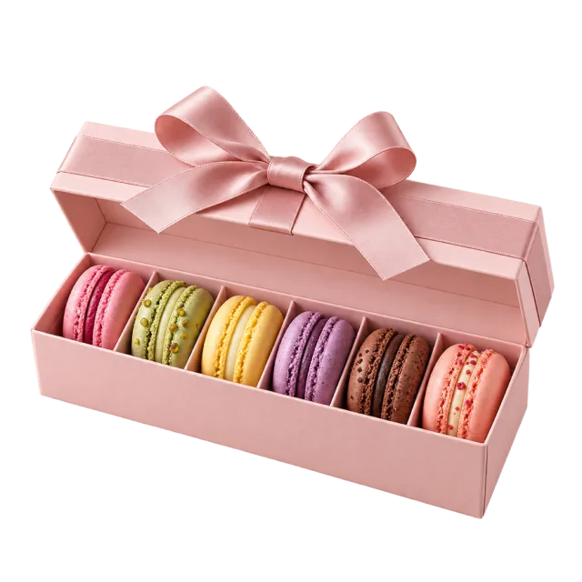A pink rectangular gift box holding a row of colorful macarons beneath a ribbon lid