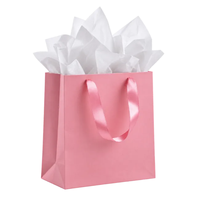 A pink paper gift bag with satin handles and white tissue paper