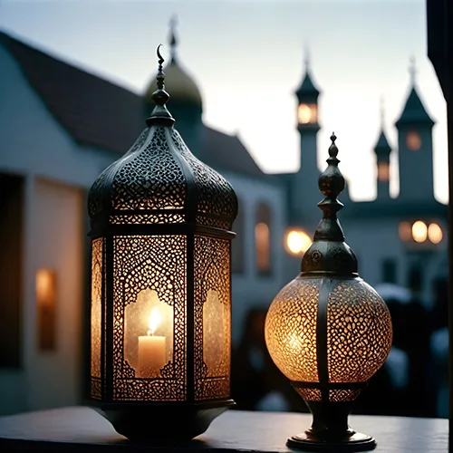 Two warm-lit lanterns in front of softly blurred mosque architecture
